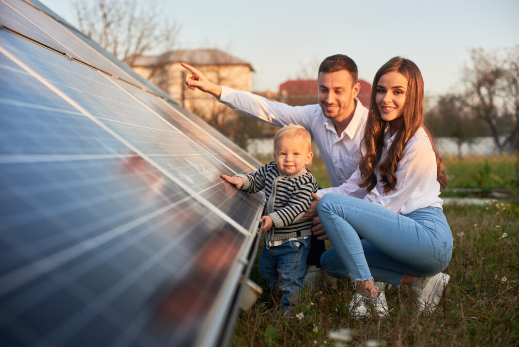 Famiglia davanti a pannelli fotovoltaici